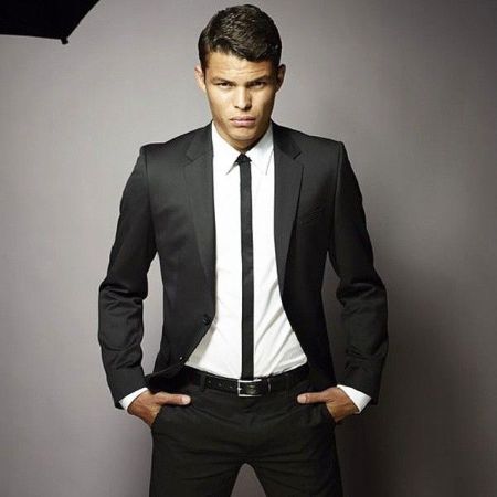 Thiago Silva in a black suit poses for a picture.